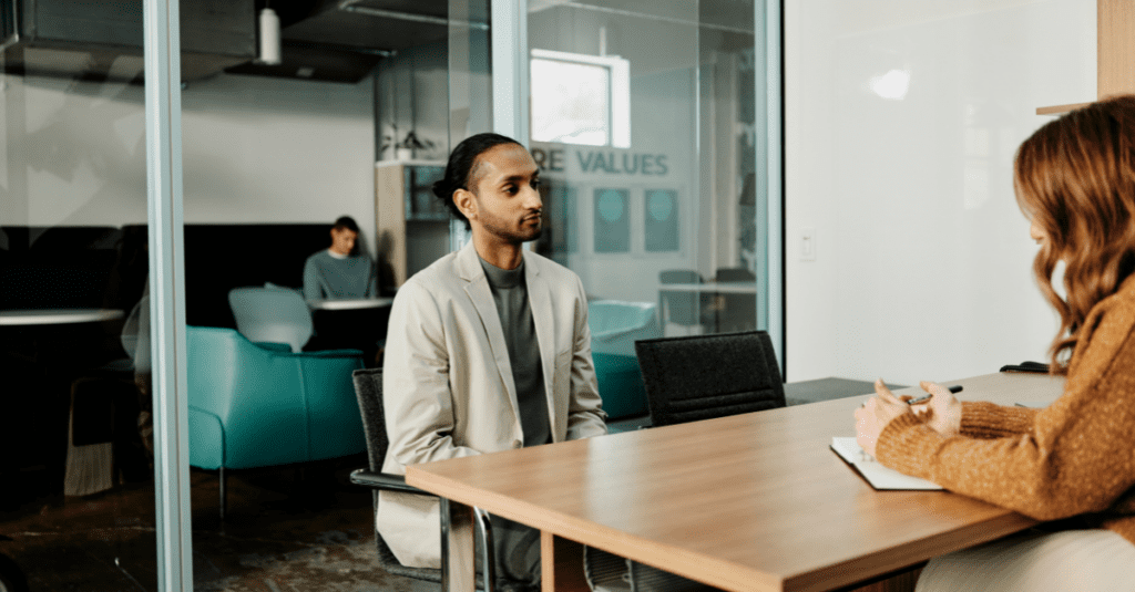 Man is sitting in a job interview setting